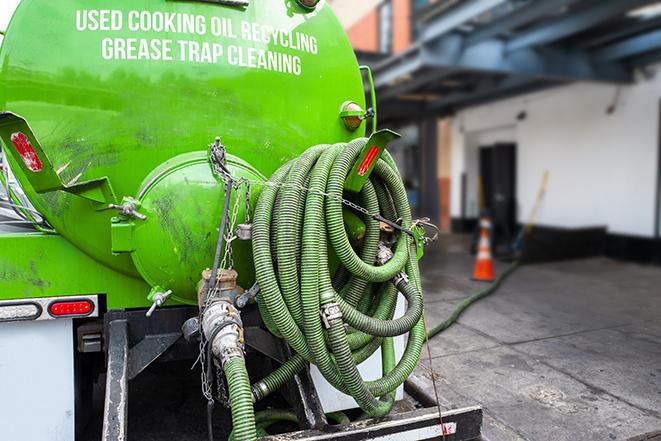 a grease trap being pumped by a sanitation technician in Irvington, NJ